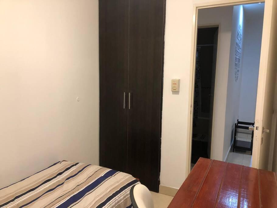 1 dormitorio con 1 cama y armario de madera en “Buenos Aires Estrella”- 2 dormitorios en San Miguel de Tucumán