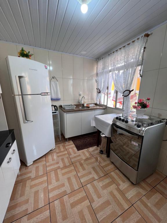 uma cozinha com um frigorífico branco e um fogão em Casa privativa completa e aconchegante! em São José