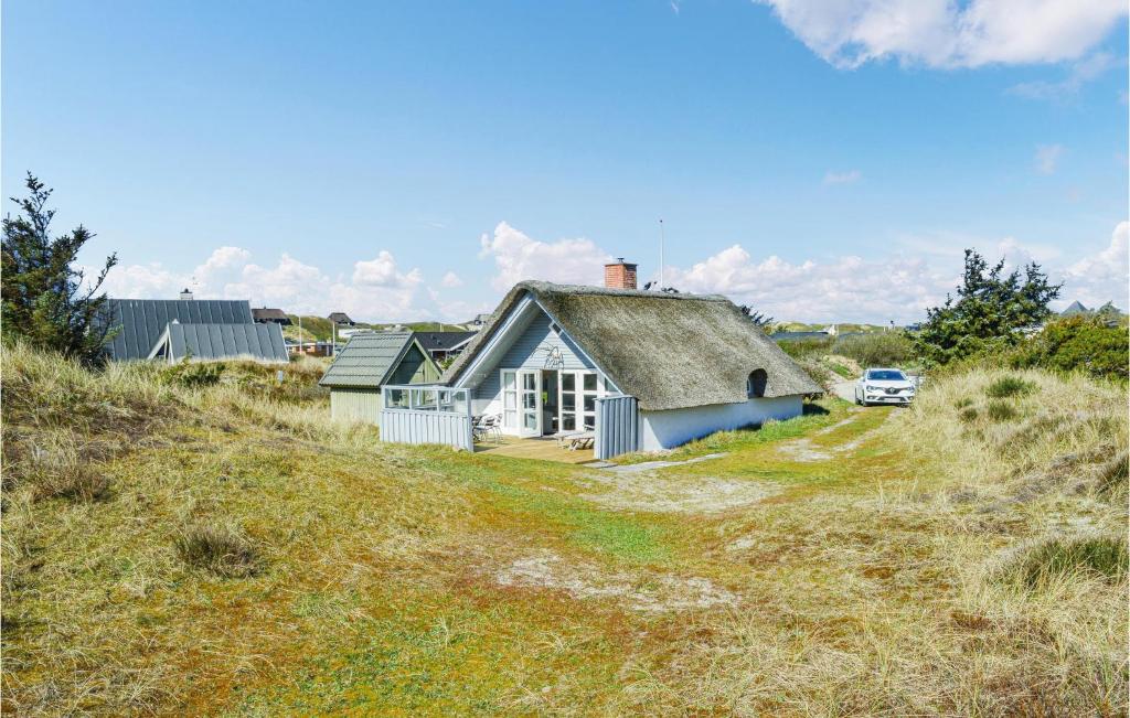 a house on the side of a grassy hill at West-side in Søndervig