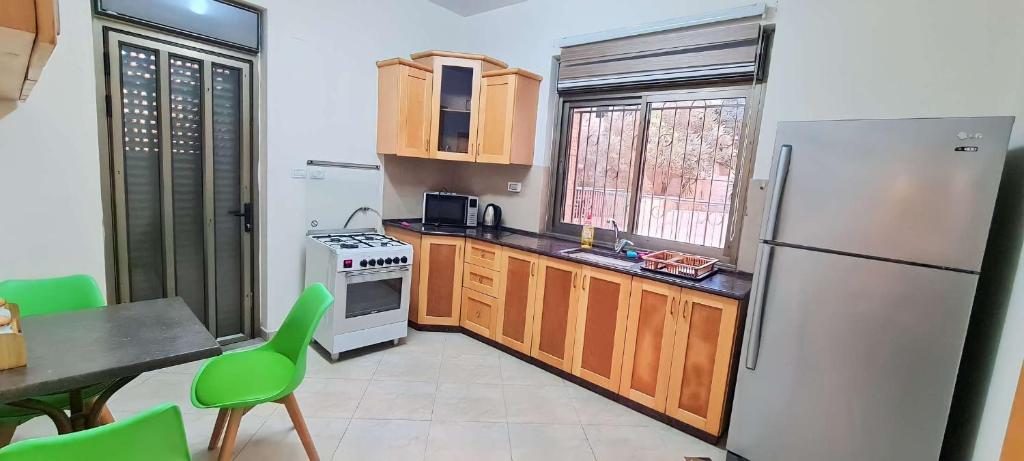 a kitchen with a refrigerator and a table and chairs at CityCenter Charm in Ramallah