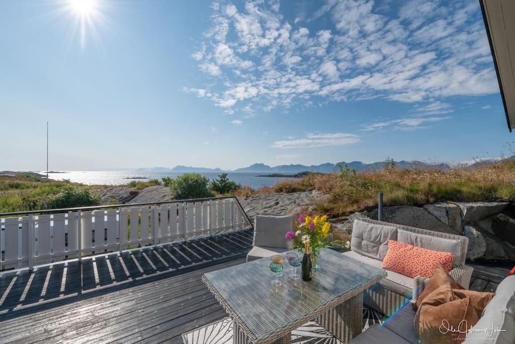 patio ze stołem i krzesłami oraz widokiem na wodę w obiekcie Henningsvær, Lofoten with fantastic view w mieście Henningsvær