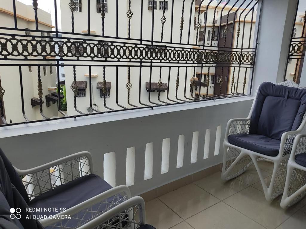 - Balcón con 2 sillas y valla en Apartamento de 2 habitaciones con inversor y seguridad 24/7 en Villa Mella