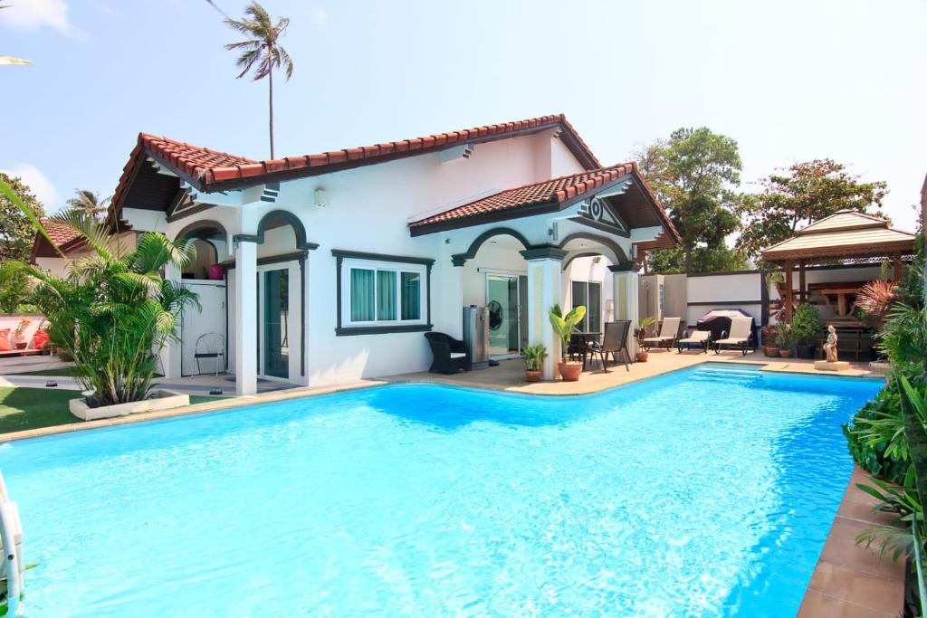 a villa with a swimming pool in front of a house at 5 Bedroom Villa in Fisherman’s Village in Bophut 