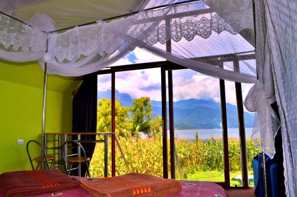 ein Schlafzimmer mit einem Bett und einem großen Fenster in der Unterkunft Mundo Abu San Juan La laguna in San Juan La Laguna
