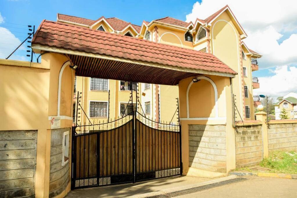 Elegantly furnished studio في نيروبي: منزل به بوابة سوداء وسياج