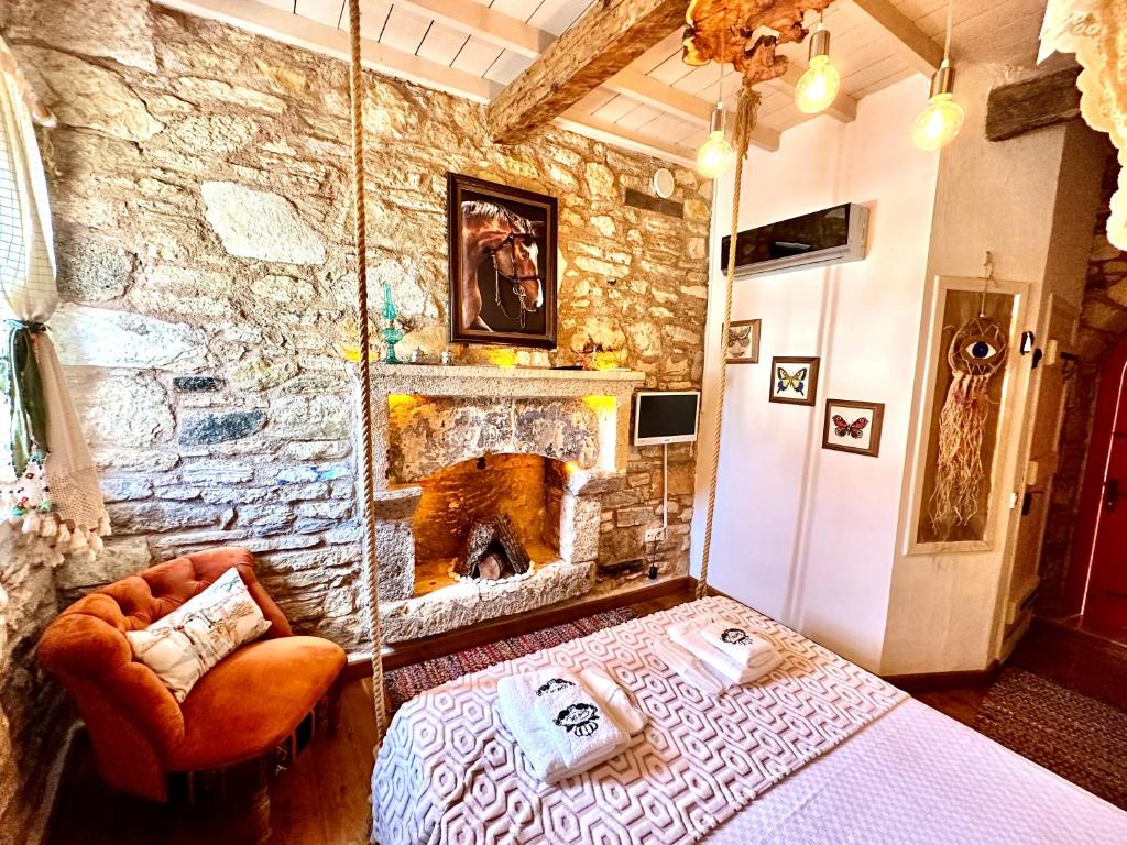 1 dormitorio con pared de piedra, cama y chimenea en Marissa Boutique Hotel, en Cesme