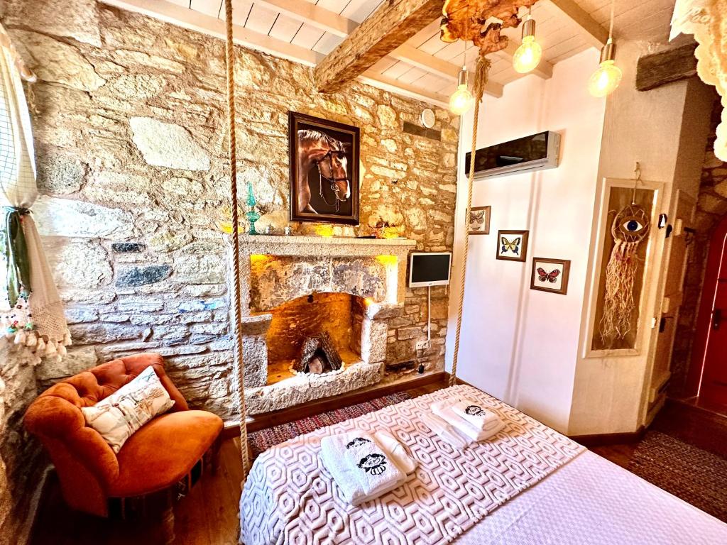 a bedroom with a stone wall with a bed and a fireplace at Marissa Boutique Hotel in Çeşme