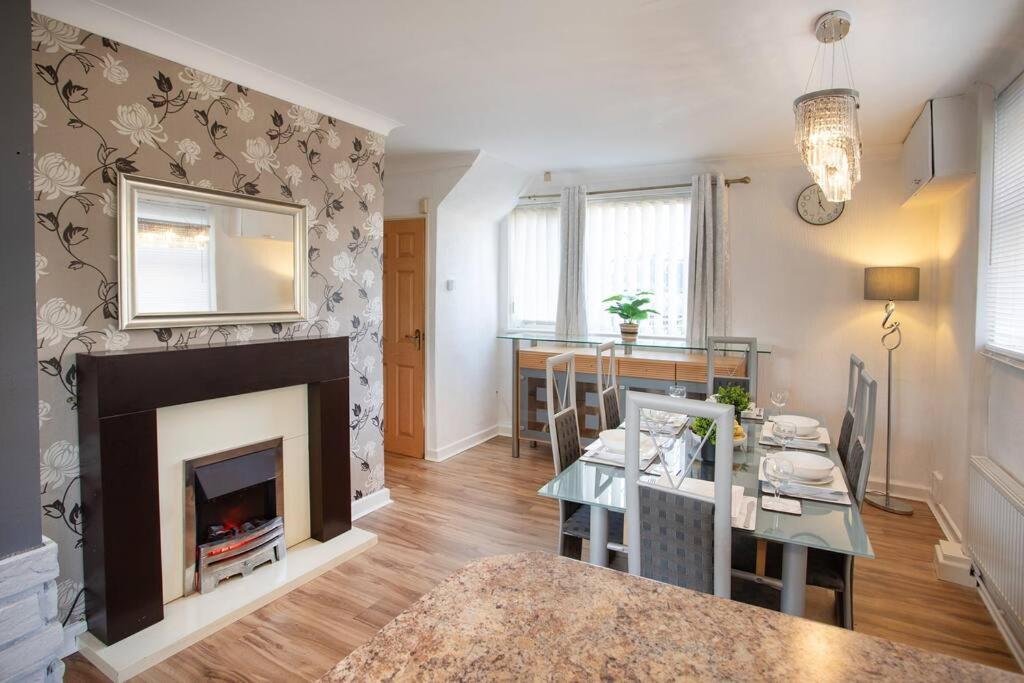a living room with a fireplace and a dining room at Rawmarsh House, Rotherham for Contractors, Business & families -Monthly Discount in Rotherham