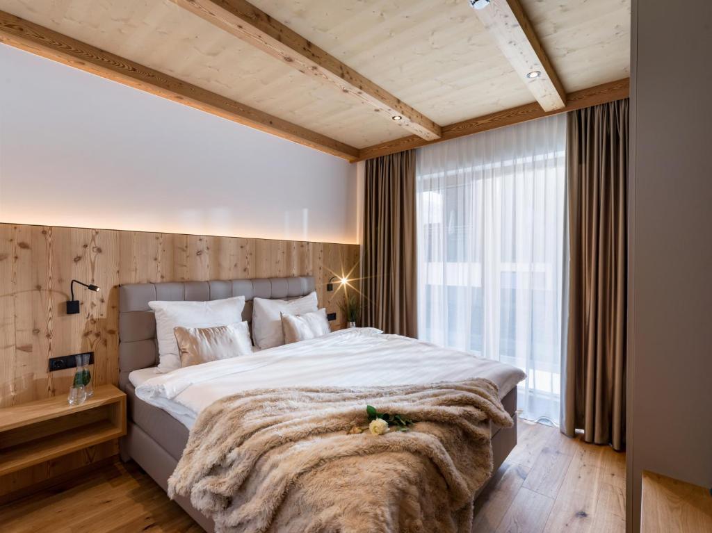 a bedroom with a large bed and a large window at Das Bergjuwel in Auffach