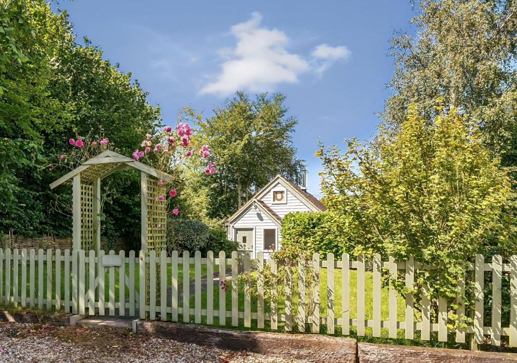 a white fence in front of a white house at Stable Cottage in Dorchester