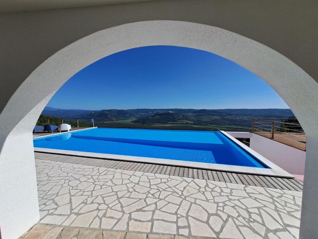 vista sulla piscina attraverso un arco di Villa San Silvestro a Oprtalj