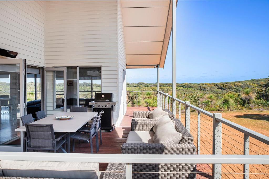 a patio with a table and chairs on a balcony at Cantley at Flutes Estate, Margaret River in Wilyabrup