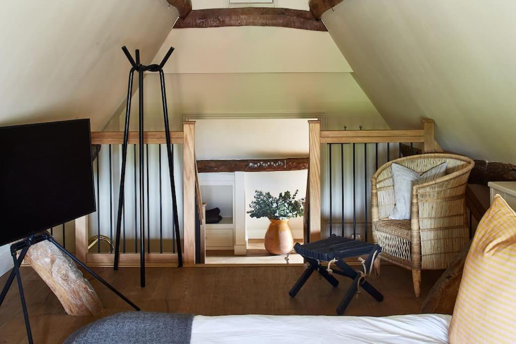 a room with a mirror and a chair and a table at Dawn at The Sun Inn Felmersham, Our Signature Duplex Suite in Sharnbrook