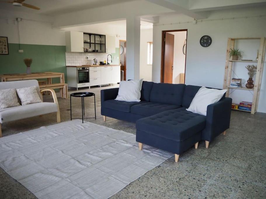 uma sala de estar com um sofá azul e uma mesa em Open and airy home 