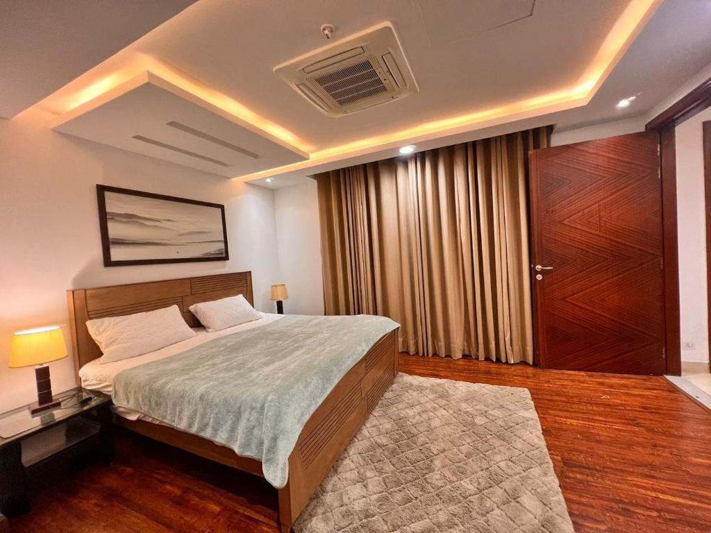 a bedroom with a large bed and a large closet at Luxurious Appartment in GOLDCREST DHA Lahore in Lahore