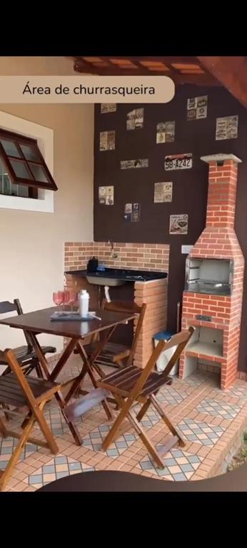 a table and chairs in a room with a fireplace at Recanto Videira Rota do Vinho in São Roque