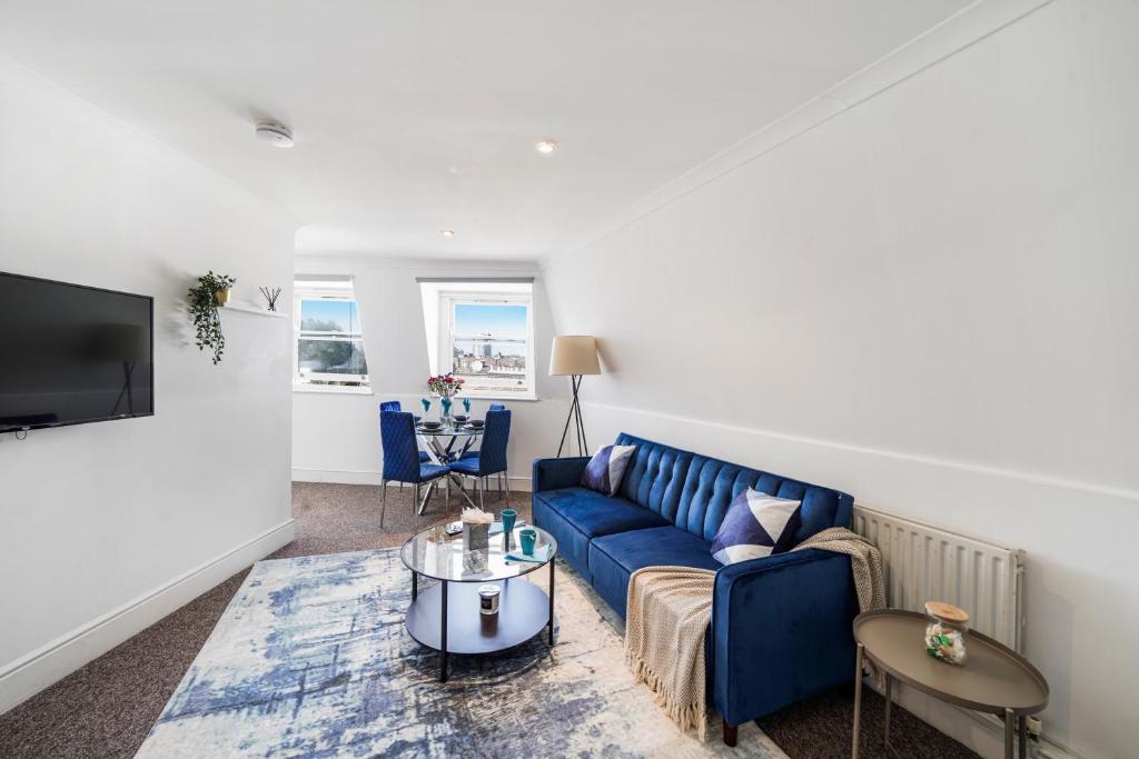 sala de estar con sofá azul y TV en LiveStay - Apartments in Bayswater London, en Londres