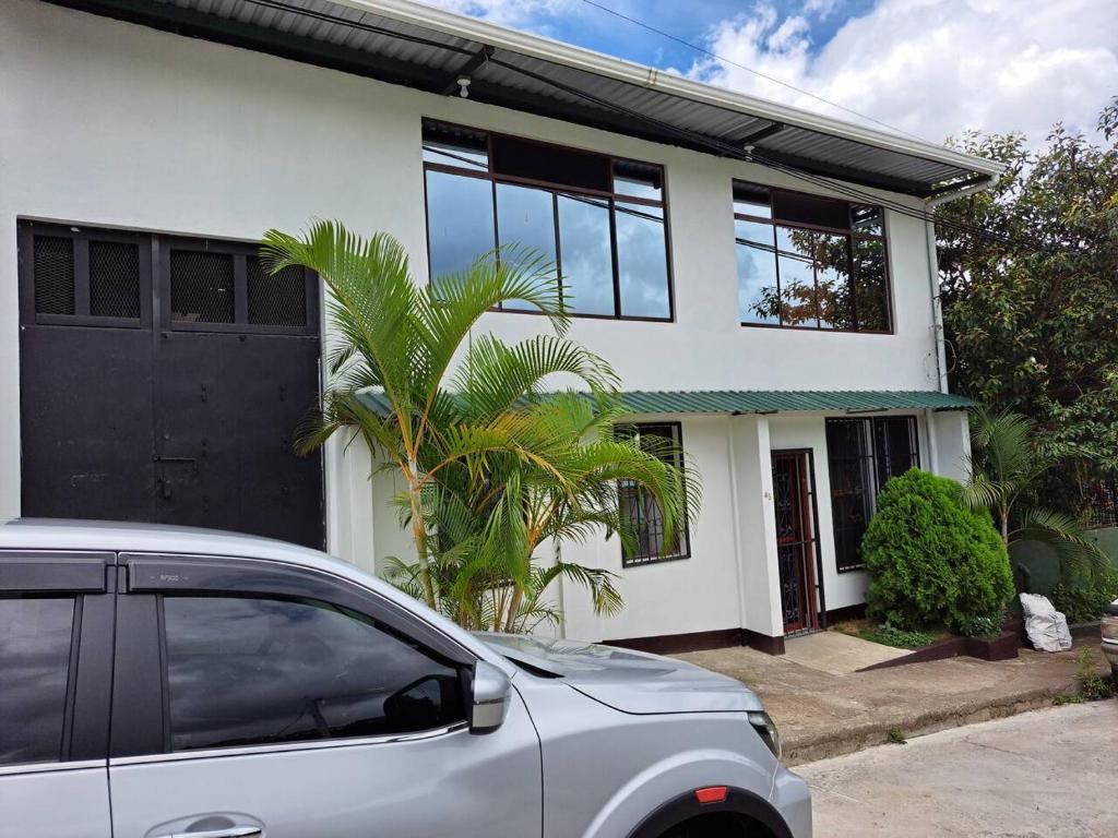 a car parked in front of a white house at Casa Isabella 45 in Matagalpa