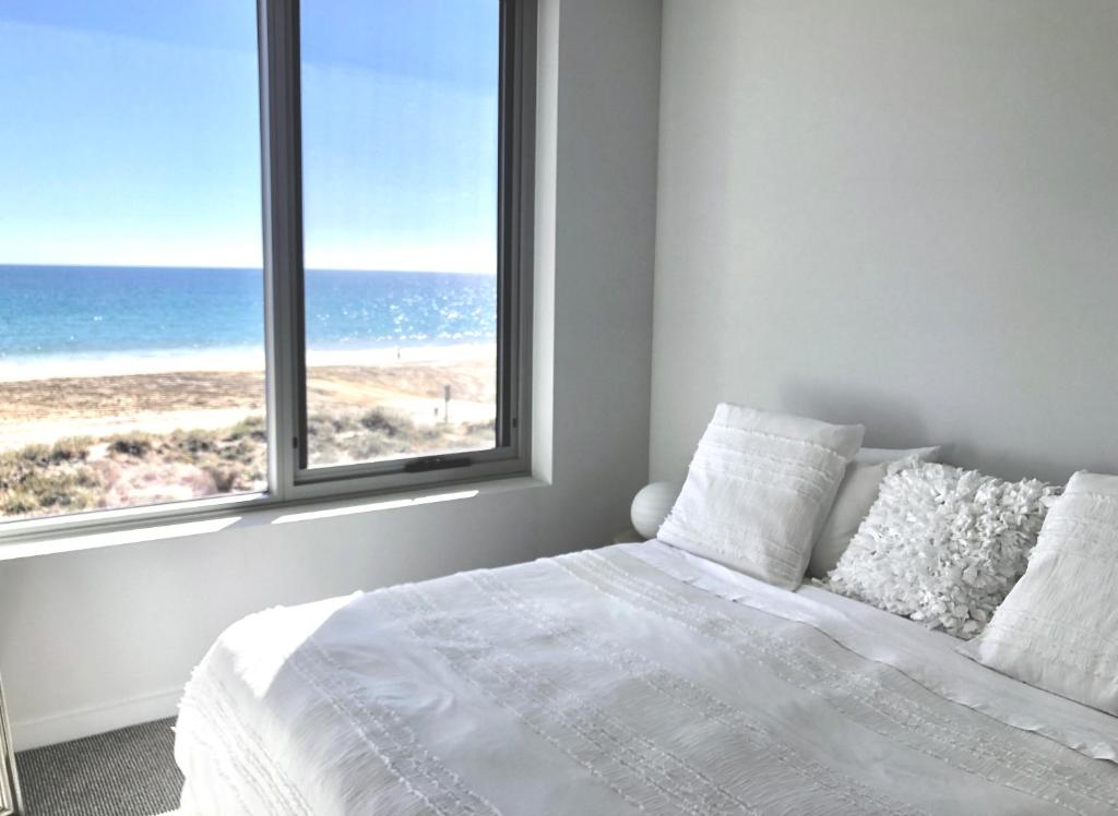 una camera con letto e vista sulla spiaggia di Luxury beachfront apartment a Moana