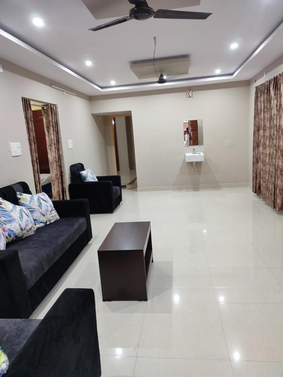 a living room with black couches and a coffee table at Rahul's Castle Guest House in Visakhapatnam