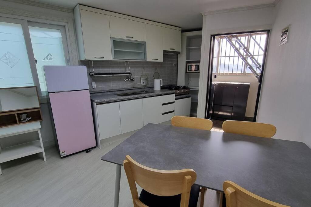 cocina con mesa, sillas y nevera en Pavilla city 401 two bedroom house en Busan