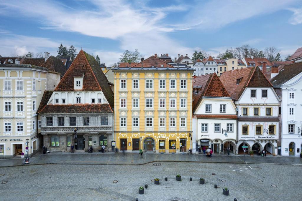 eine Gruppe von Gebäuden in einer Stadt mit einem Brunnen in der Unterkunft Siebensternehaus in Steyr