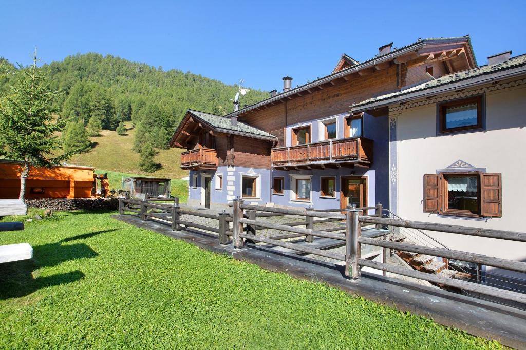 dom z drewnianym płotem przed nim w obiekcie Appartamento 3 w Livigno