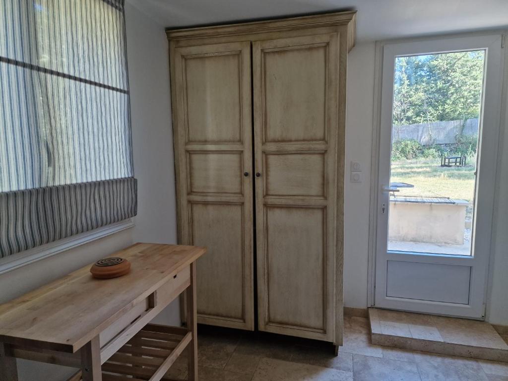 a room with a wooden cabinet next to a window at Villa des Cigales in Trets