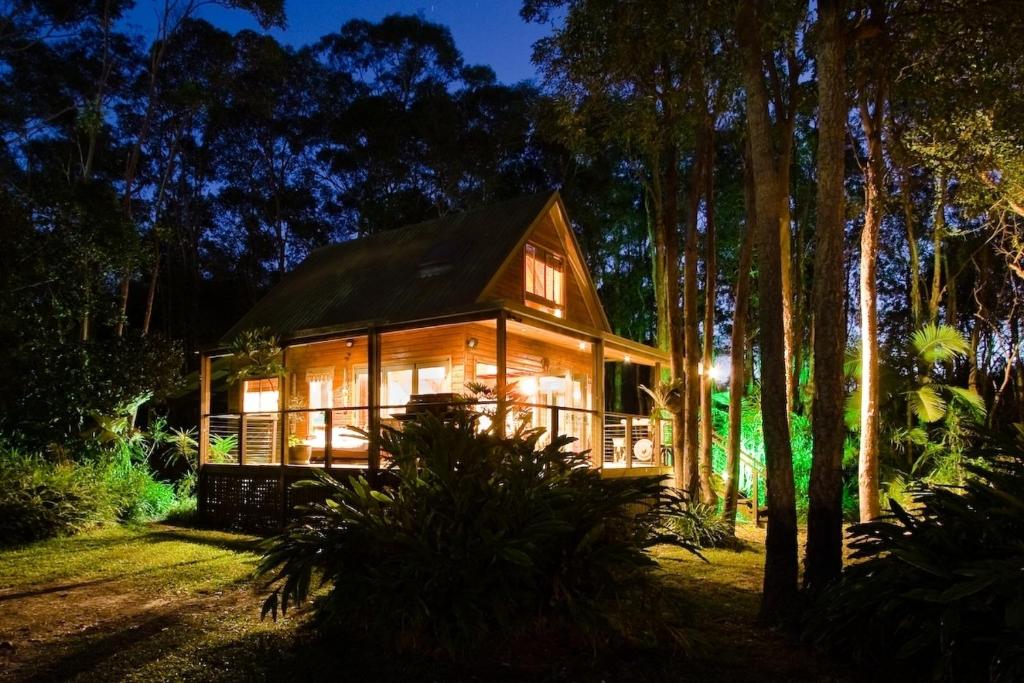a house in the middle of a forest at night at Buddha's Bungalow in Byron Bay