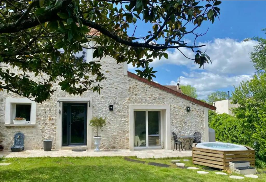 a stone house with a pool in the yard at Majoliebriarde B&B - Chambre d hôtes proche Disneyland et Paris in Saint-Germain-sur-Morin