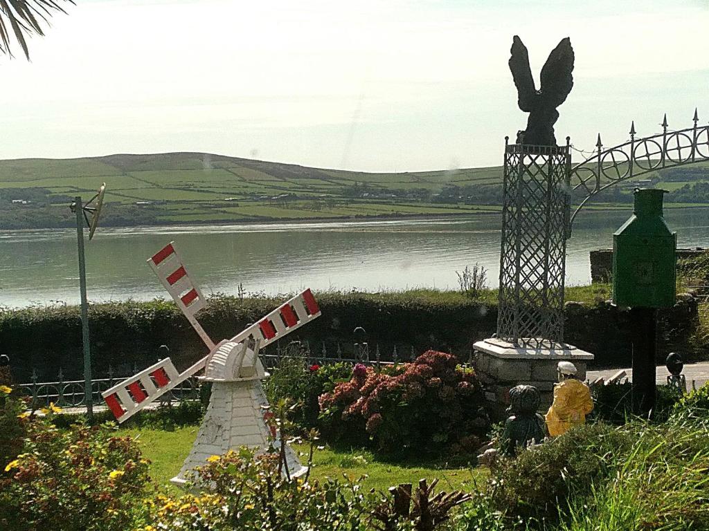 a windmill and a statue next to a body of water at The Dingle Galley in Dingle