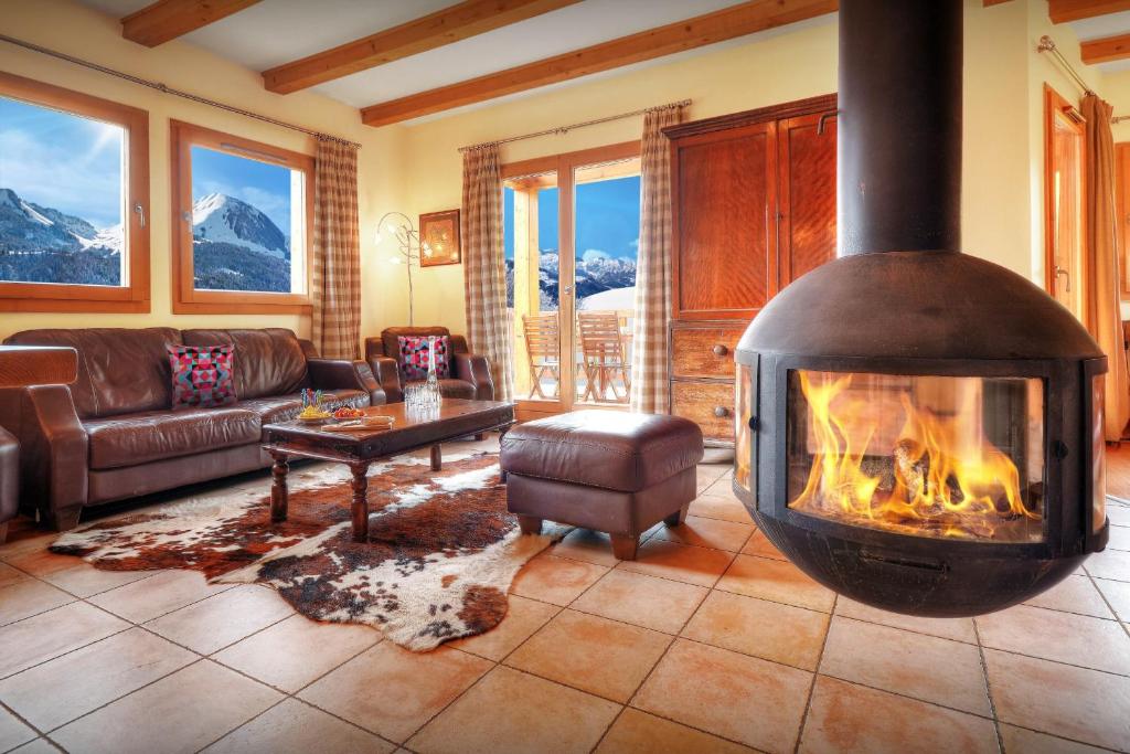 a living room with a fireplace in a lodge at Chalet la Croix Meridionale - OVO Network in Manigod