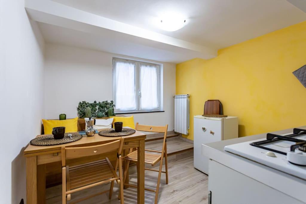 uma cozinha com uma mesa, cadeiras e um fogão em Apartment Adorno 2 - Affitti Brevi Italia em Gênova