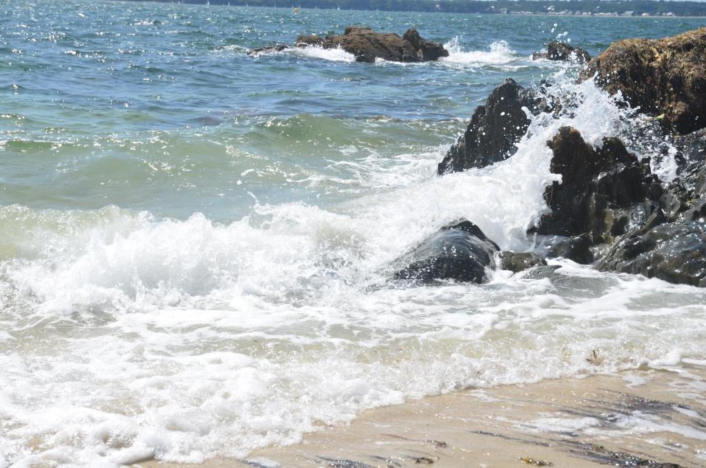 a group of waves hitting the rocks on the beach at Appartement Corniche II - Superbe Vue Mer !!! wir sprechen flieBen deutsch, Touristentipps, we speak English in Concarneau