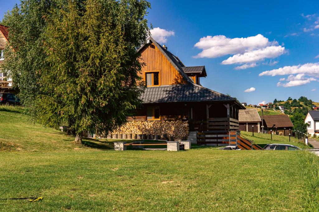 una casa en una colina con un árbol en Chata BO Hrčava en Hrčava