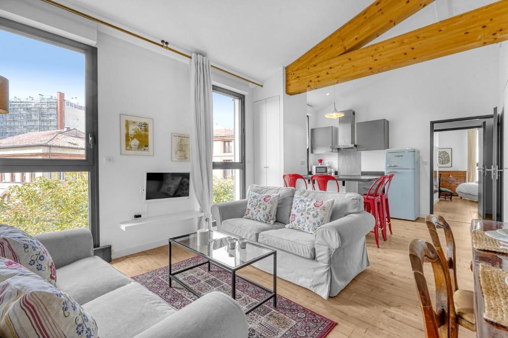 a living room with a couch and a table at Rosario - Joli T3 climatisé dans Toulouse in Toulouse