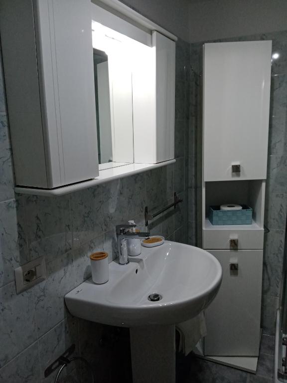un bagno con un lavandino bianco e uno specchio di La Dimora di Pietra a Gubbio
