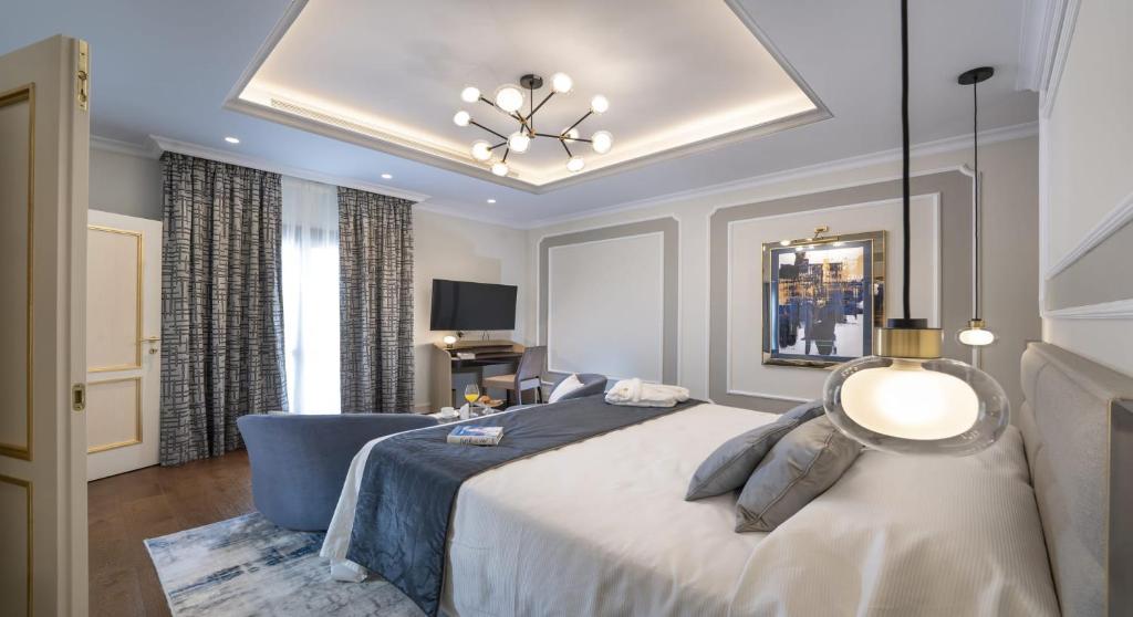 1 dormitorio con 1 cama grande y 1 silla azul en Royal Suite at The San Roque Club en San Roque