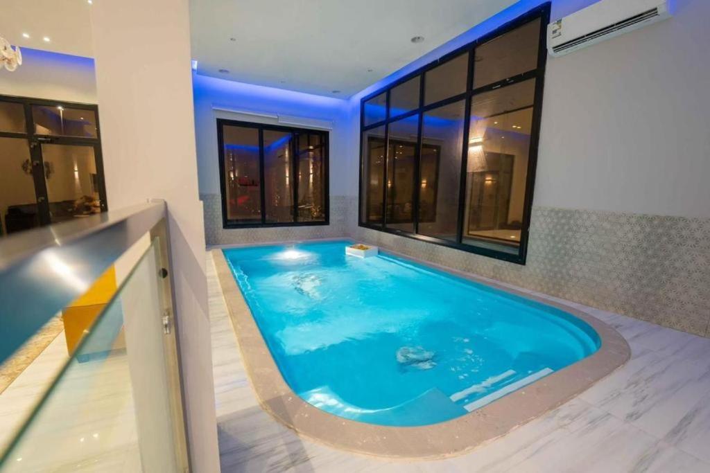 una grande piscina in una stanza con finestre di شاليهات الاطلالة a Al Khobar