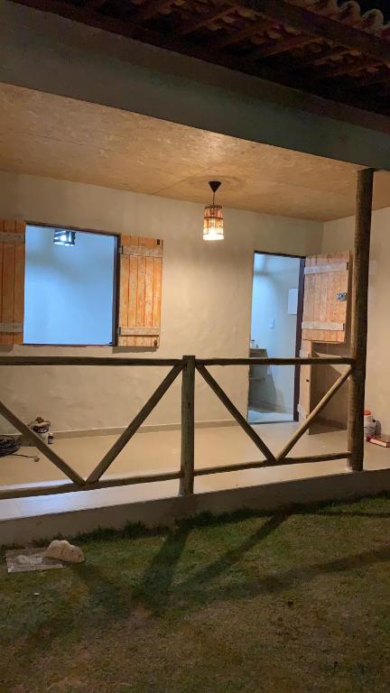 a room with a wooden fence and two windows at Chalés XIÉ in São Miguel dos Milagres