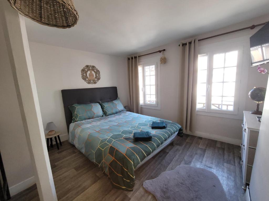 um quarto com uma cama e duas janelas em Chambre indépendante Au Relais Normand em Cormeilles
