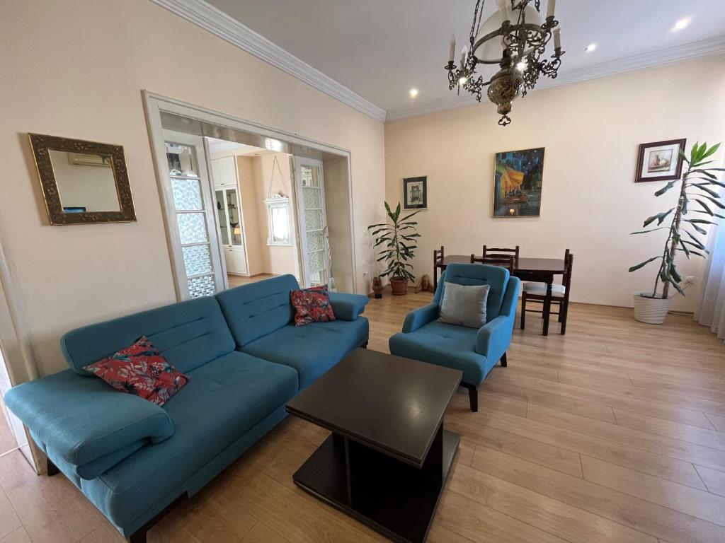 a living room with a blue couch and two chairs at Terazije Square Lux Apartment in Belgrade