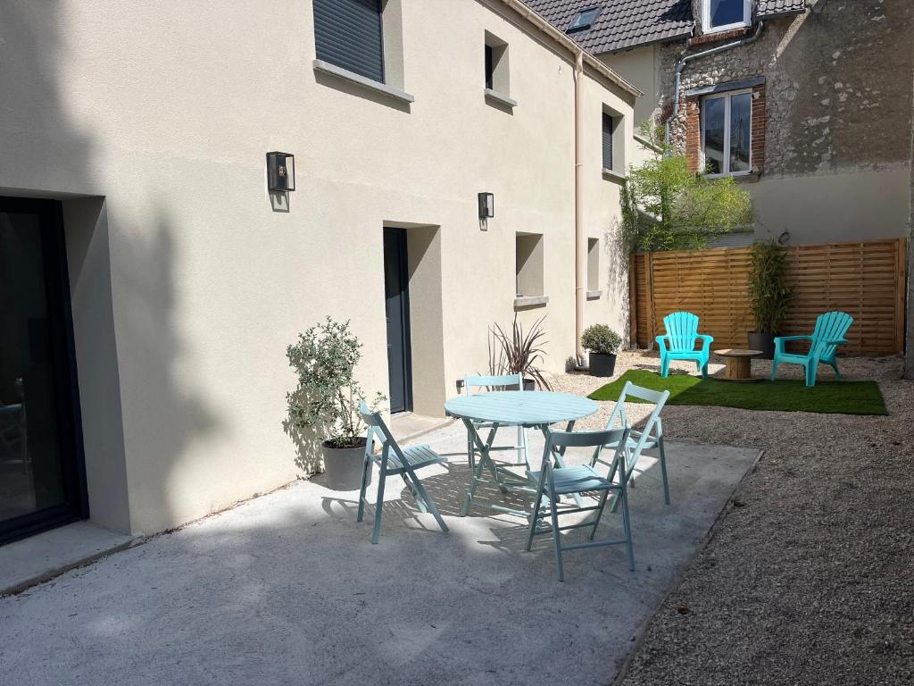 eine Terrasse mit einem Tisch und Stühlen vor einem Gebäude in der Unterkunft Maison avec extérieur proche gare des Aubrais in Orléans