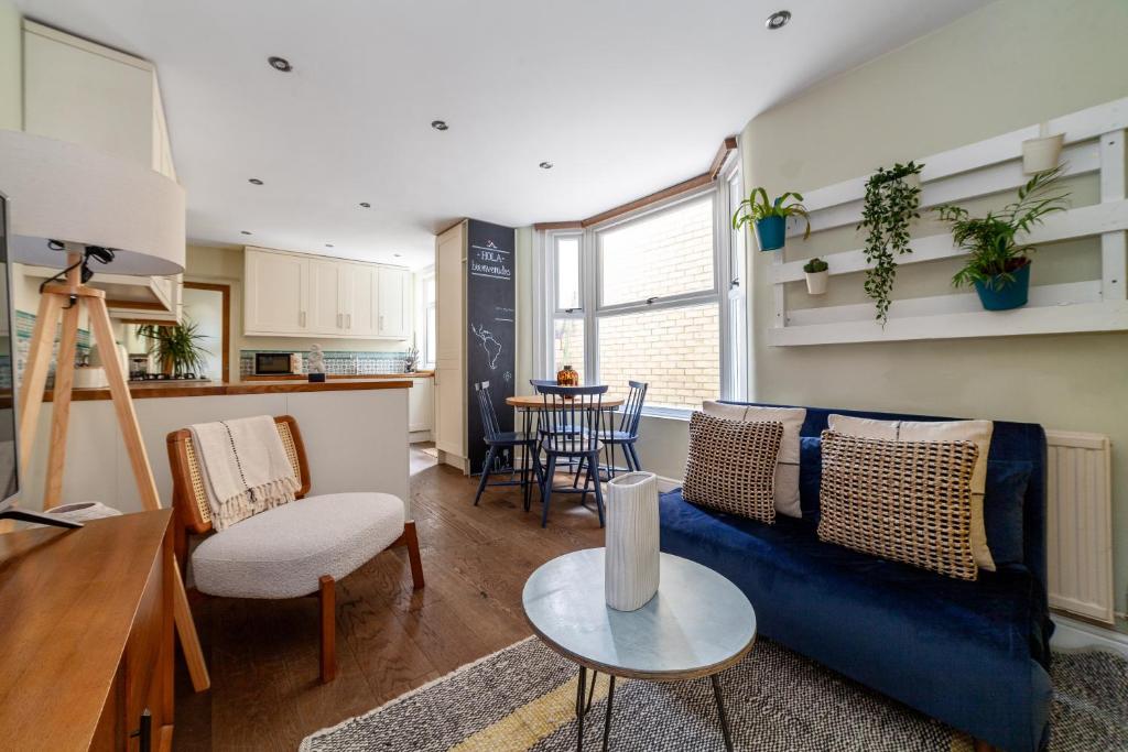 a living room with a blue couch and a table at The Queenstown Villa in London