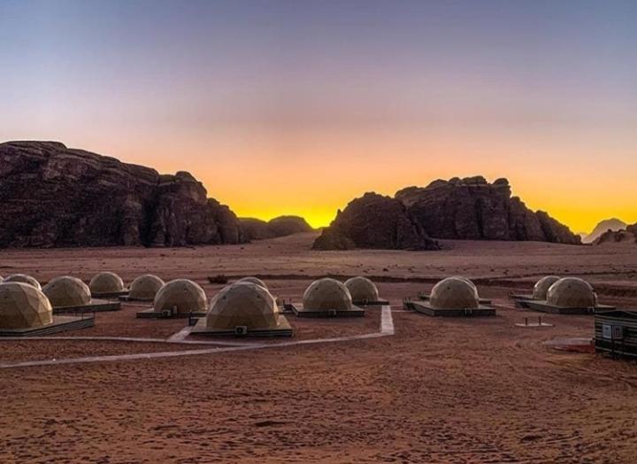 a group of domes in the desert at sunset at Wadi Rum Calma camp in Aqaba