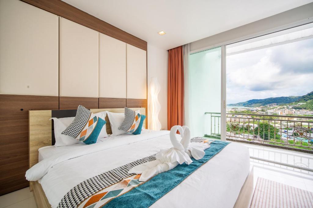 a bedroom with a bed with a large window at patong villa2：四卧泳池别墅/两个海景房/近班赞酒吧街 in Patong Beach