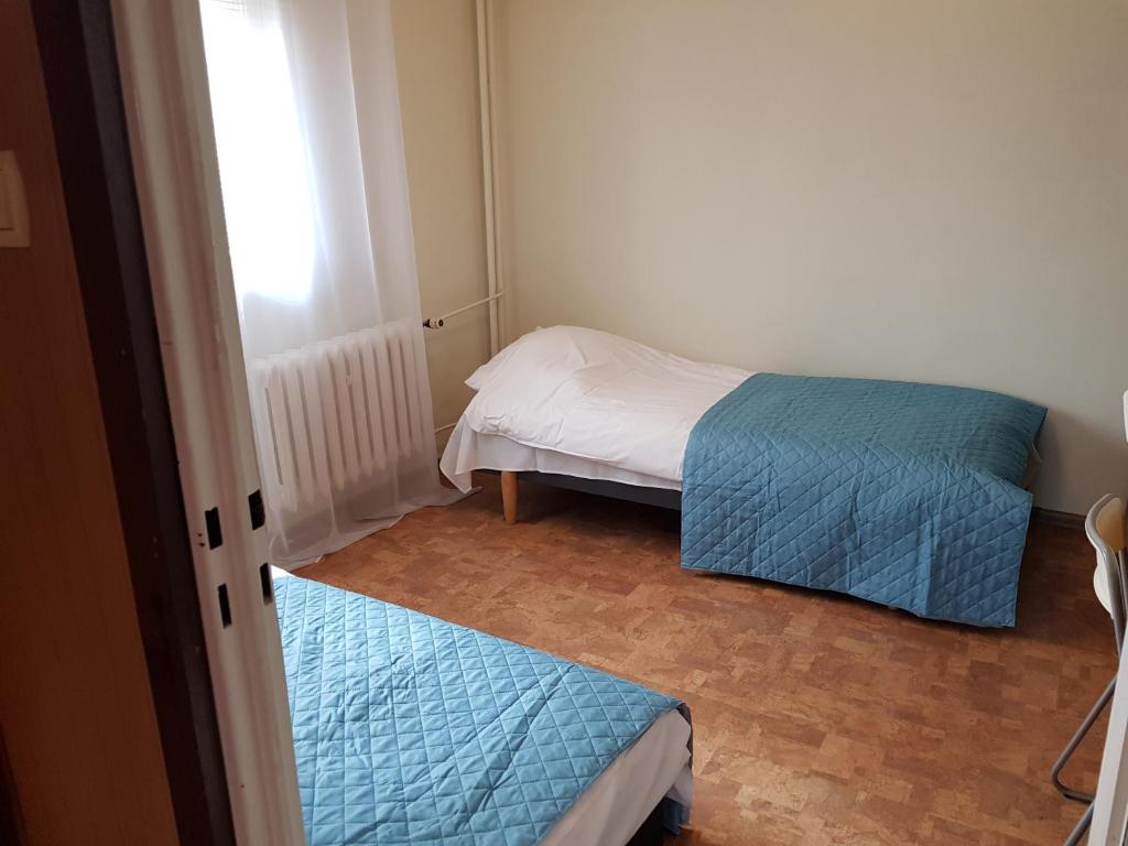 una piccola camera con due letti e una finestra di TANI apartament a Łódź