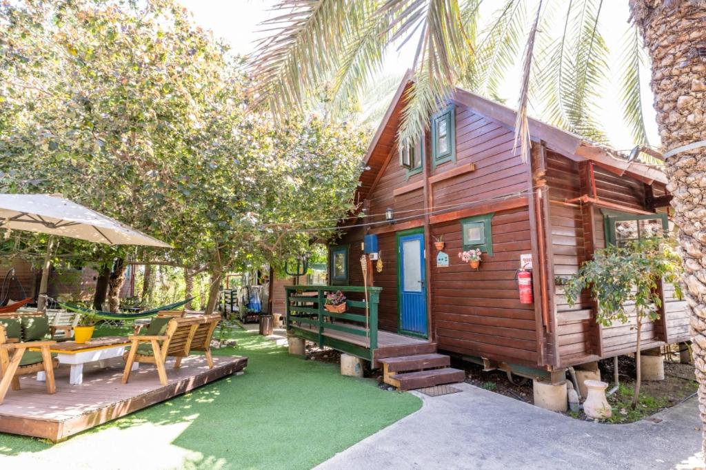 een houten huis met een tafel en een patio bij family cabin in Menaẖemya
