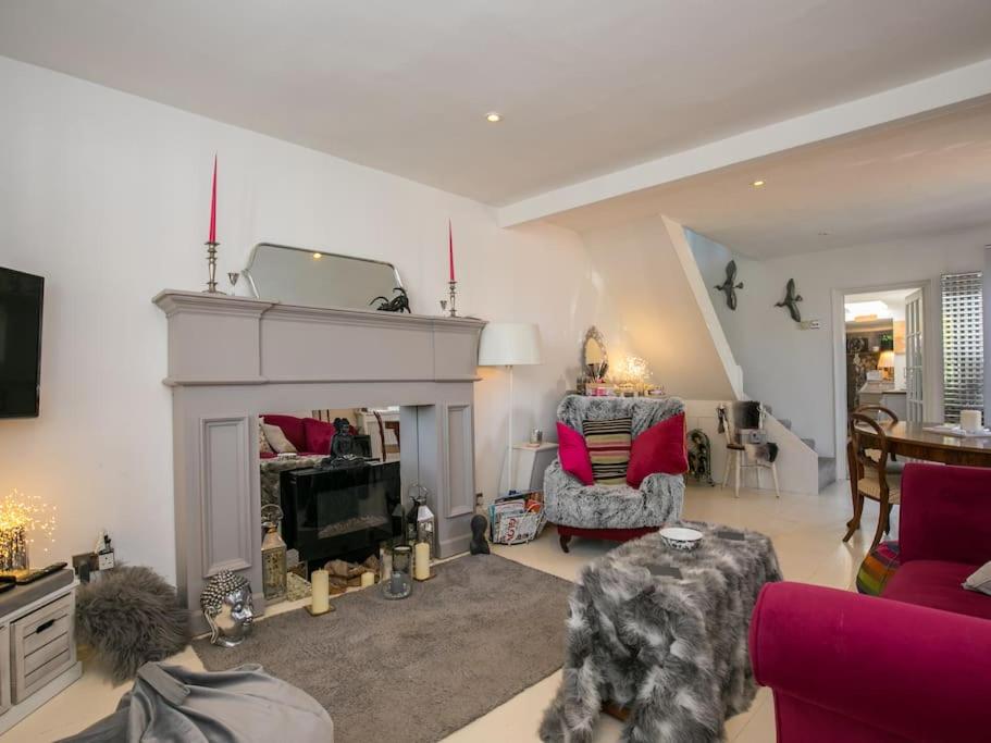 a living room with a fireplace and red furniture at Gorgeous House near Windsor & River Thames in Datchet