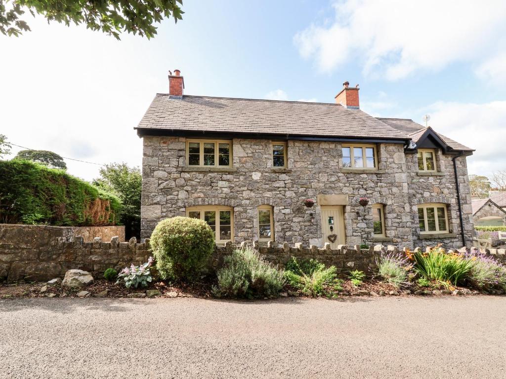 an old stone house with a gravel driveway at Garreg Wen in Holywell